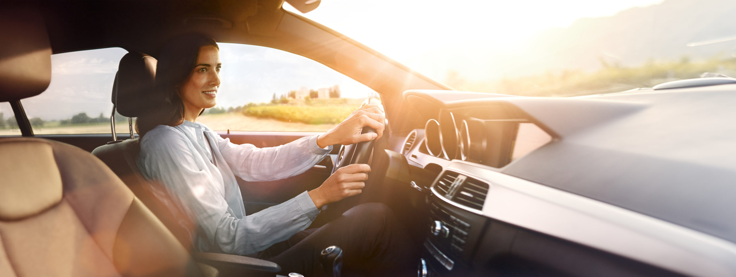 Eine Frau sitzt entspannt am Steuer eines Fahrzeuges