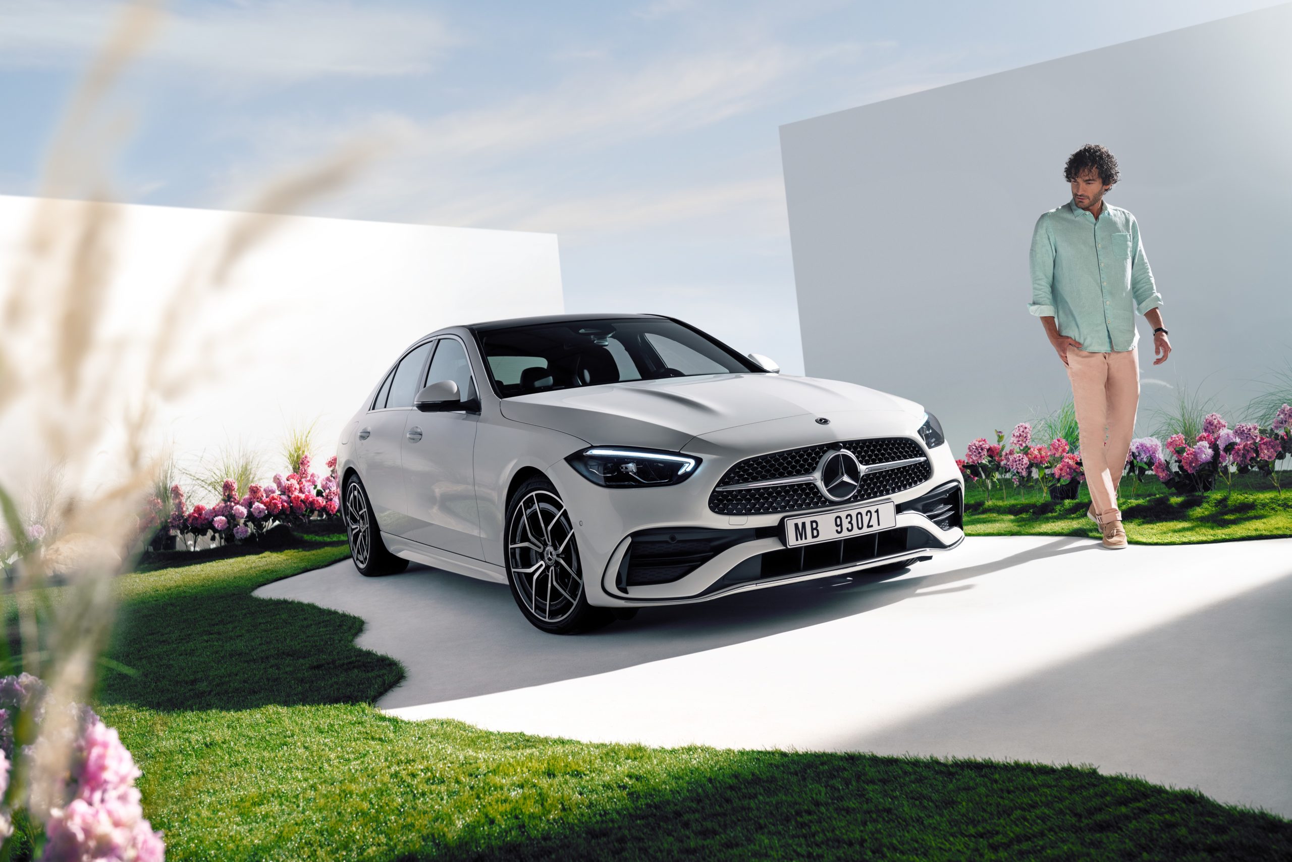 Weißer Mercedes-Benz vor frühlingshafter Kulisse