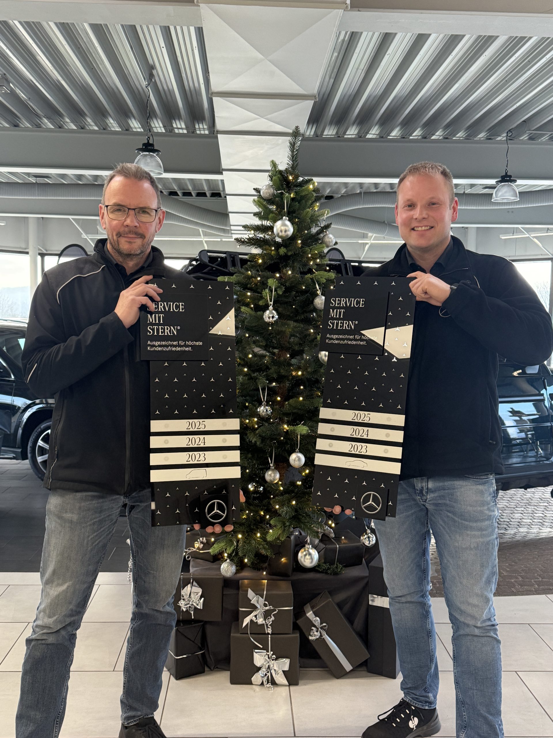 Zwei Service-Mitarbeiter halten die Auszeichnungen